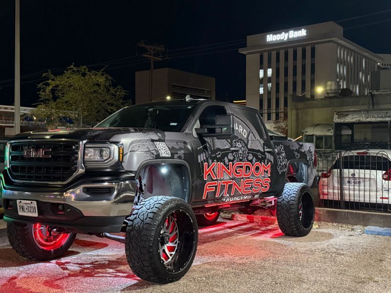 A truck is parked in front of a building at night.