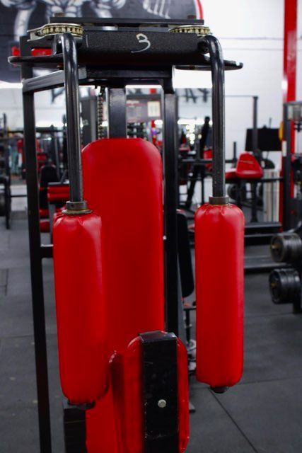 A red machine is sitting in a gym.