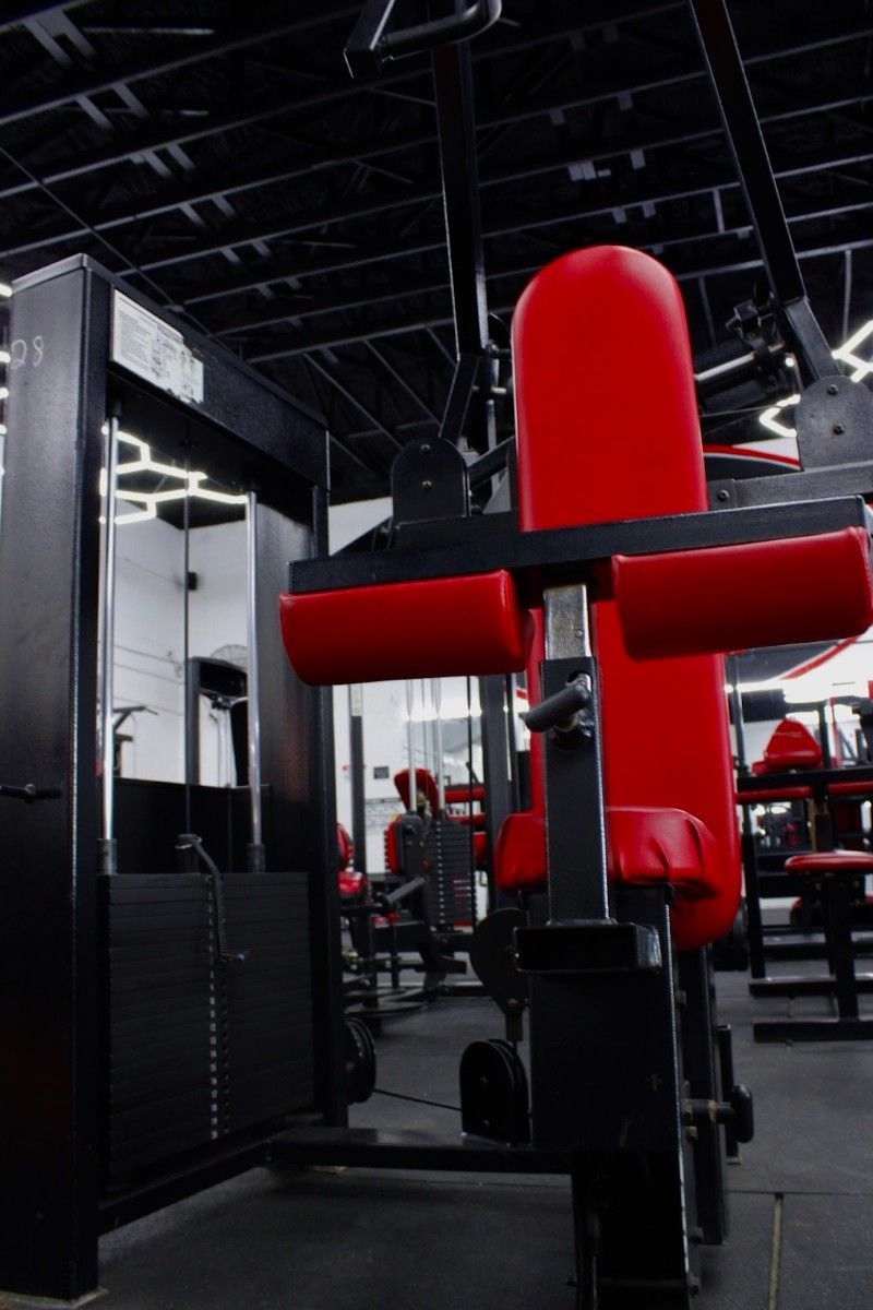 A gym with a red machine that looks like a motorcycle