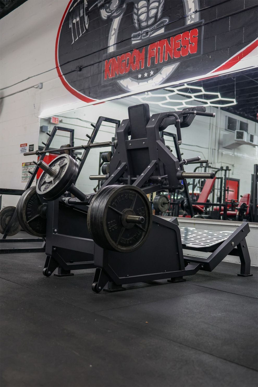 Weightlifting machine with weight plates in a gym.