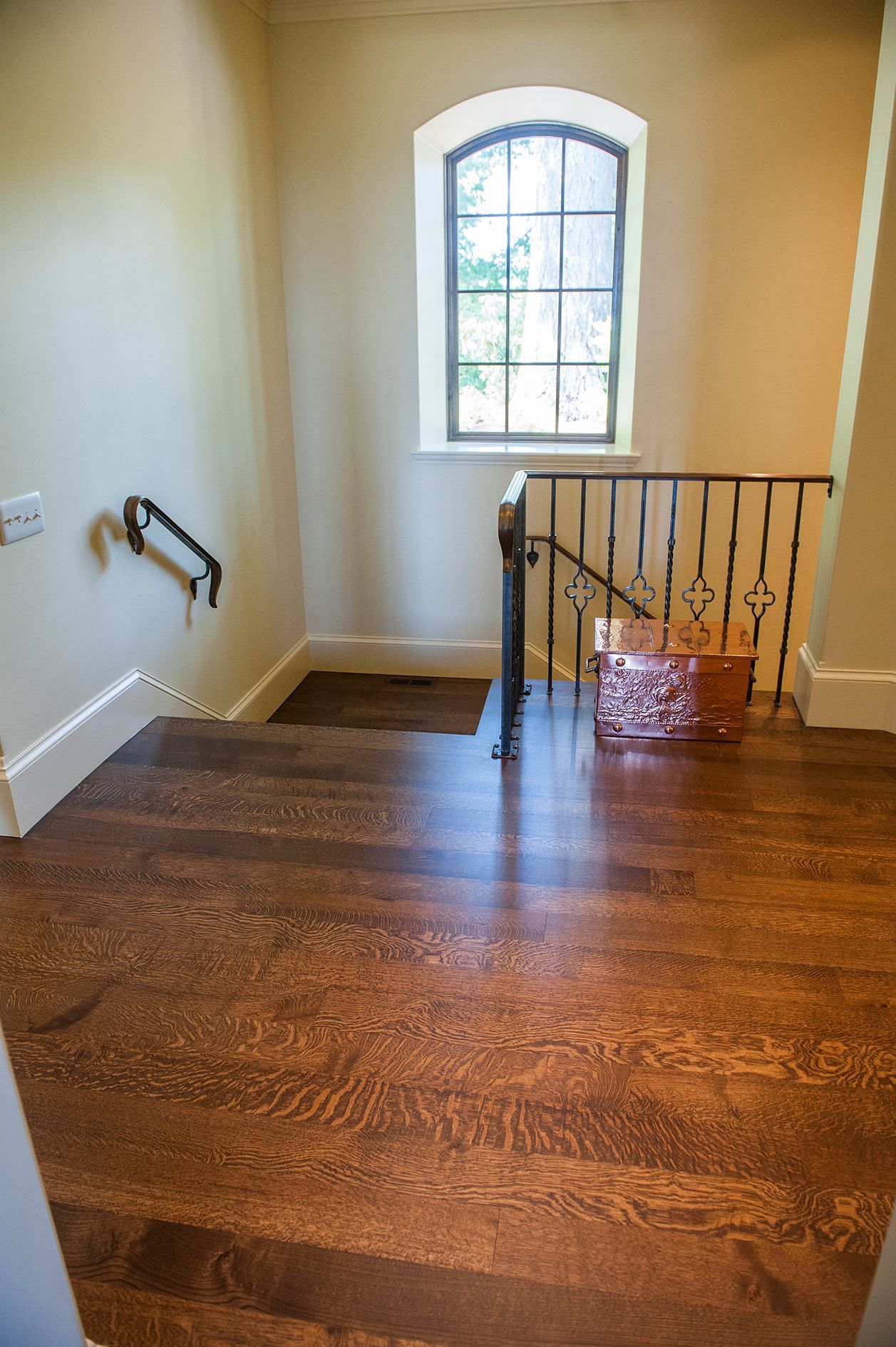 a staircase with wooden floors and a window in a house