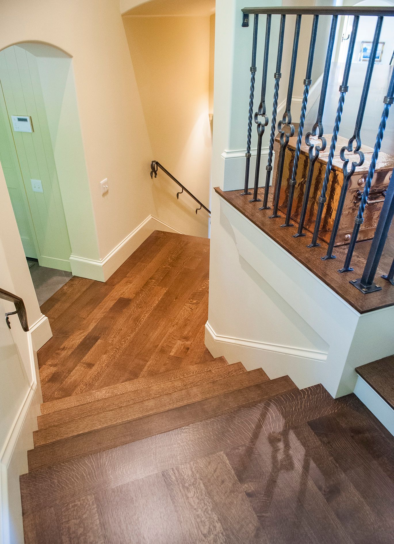 a staircase with wooden floors and a wrought iron railing