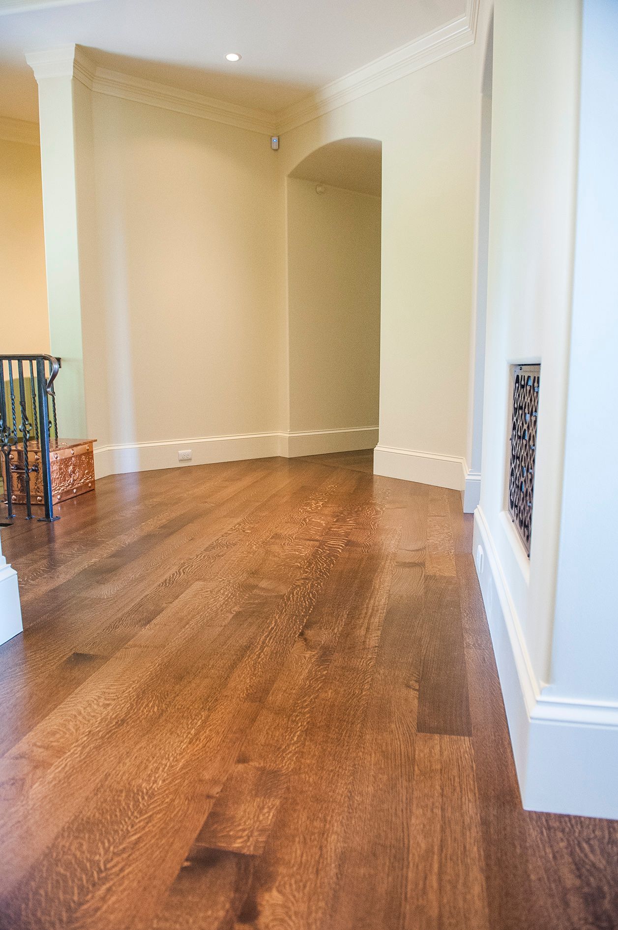 a hallway with hardwood floors and white walls in a house