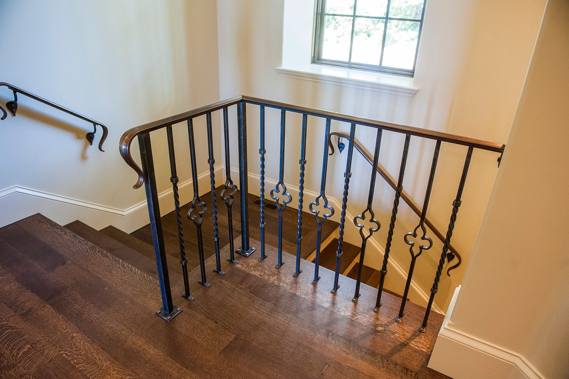 a staircase with a wrought iron railing and a window