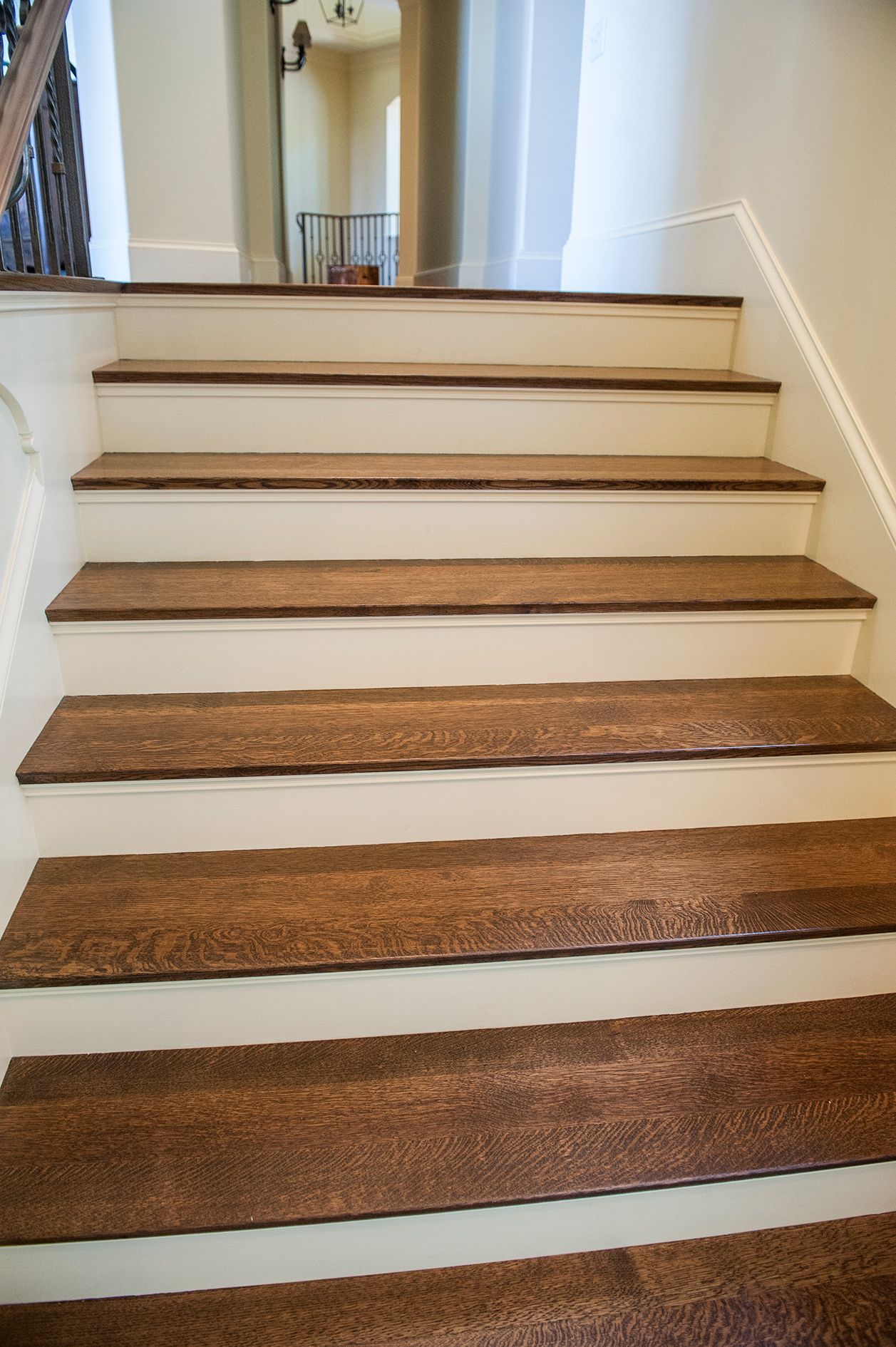 a set of wooden stairs with white steps in a house