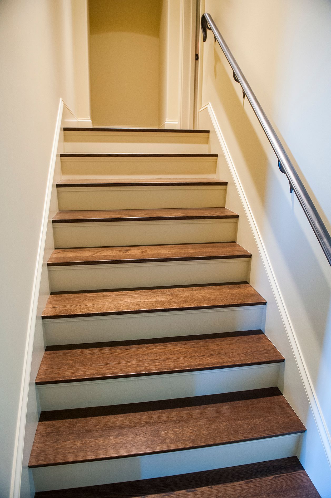 a set of stairs leading up to a hallway with a metal railing