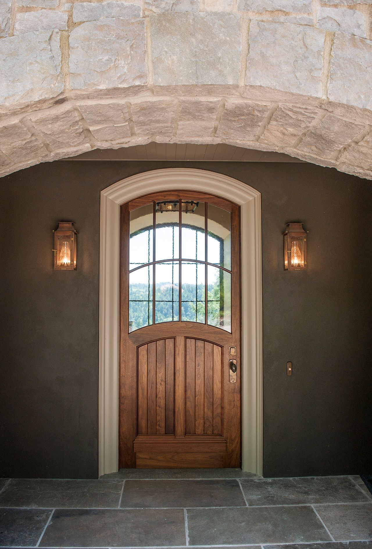 a wooden door is surrounded by a stone archway