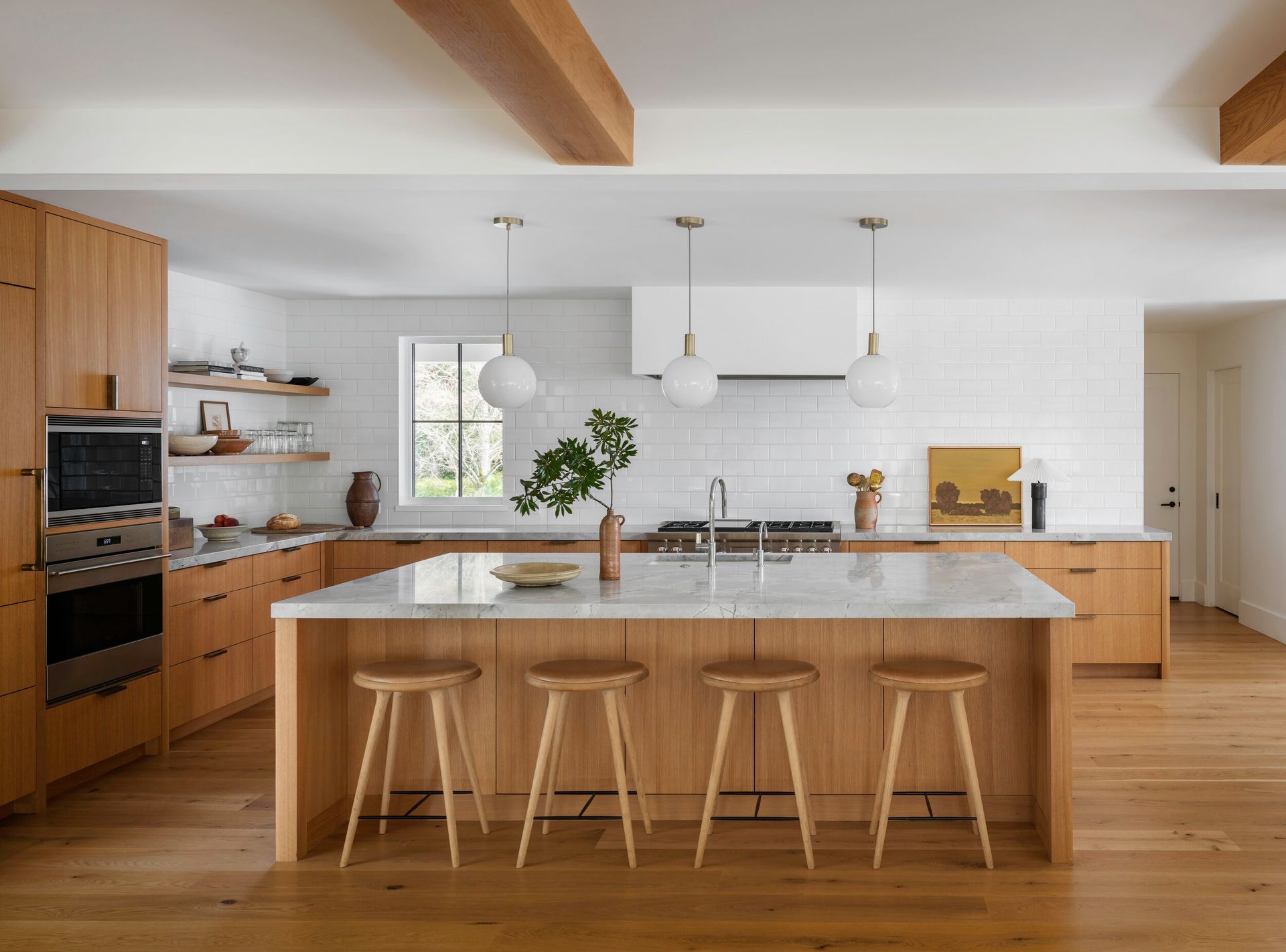 a kitchen with wooden cabinets, marble counter tops, and stools