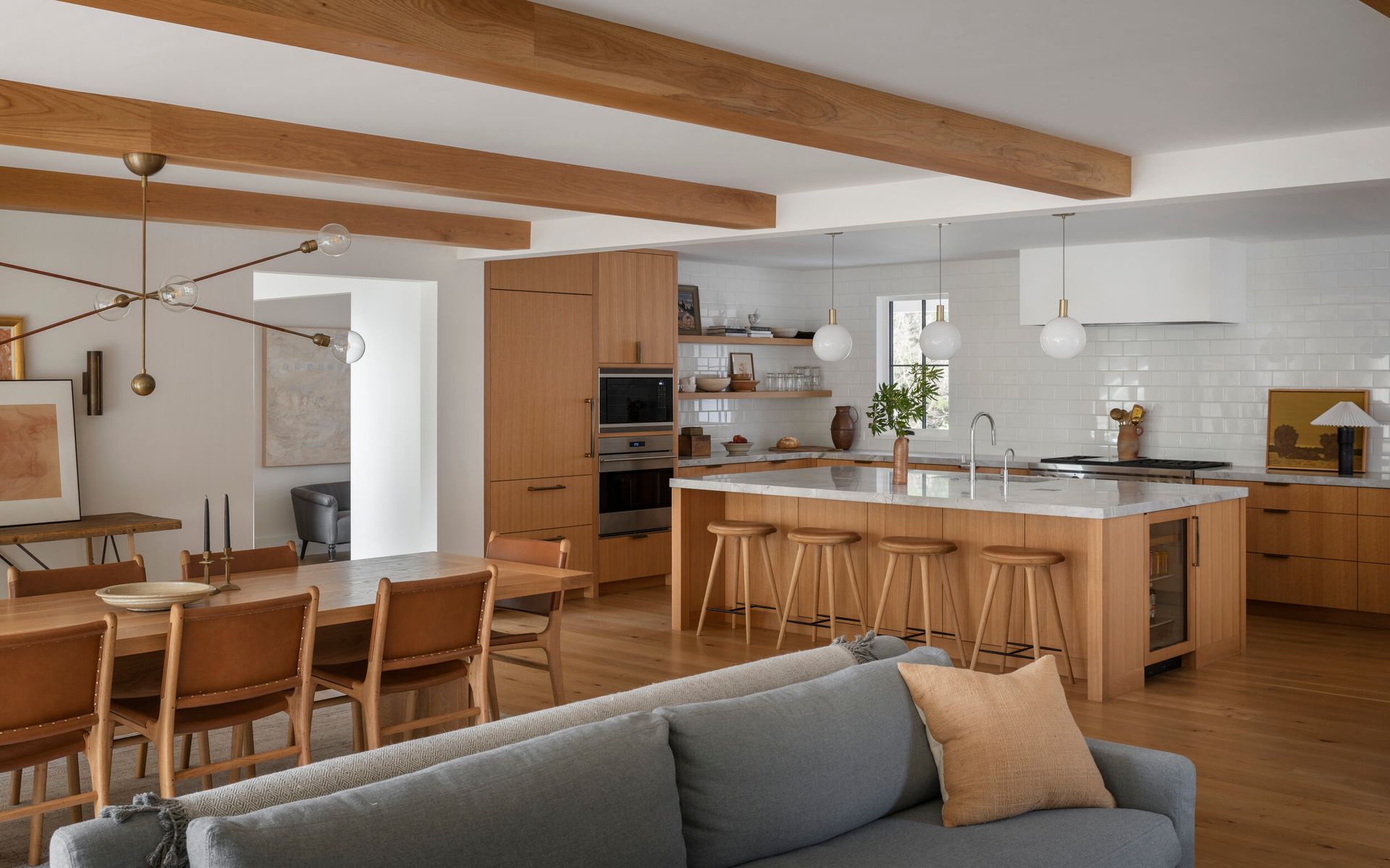 a living room with a couch, table, chairs, and a kitchen