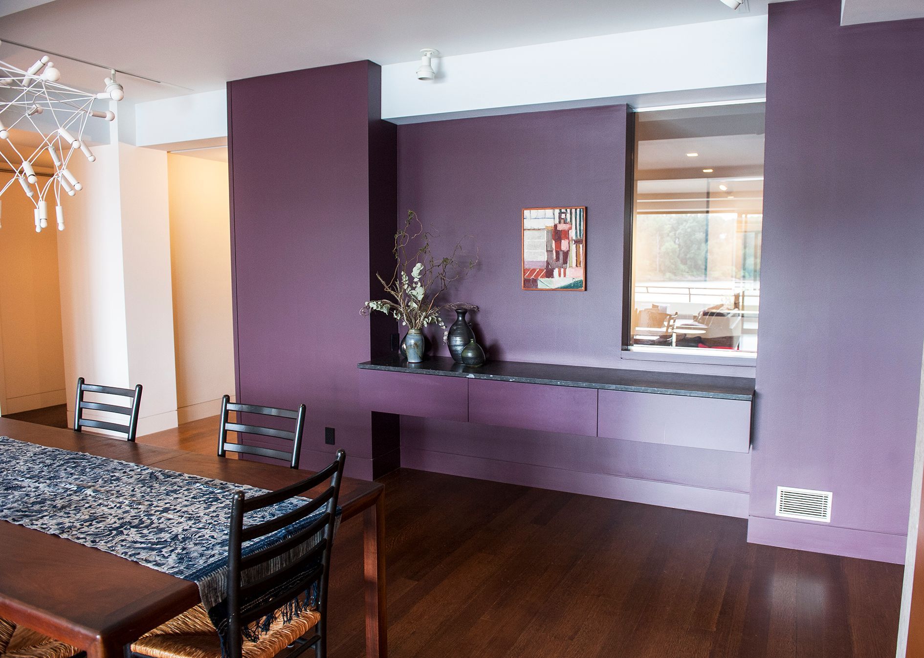 a dining room with purple walls and a table and chairs