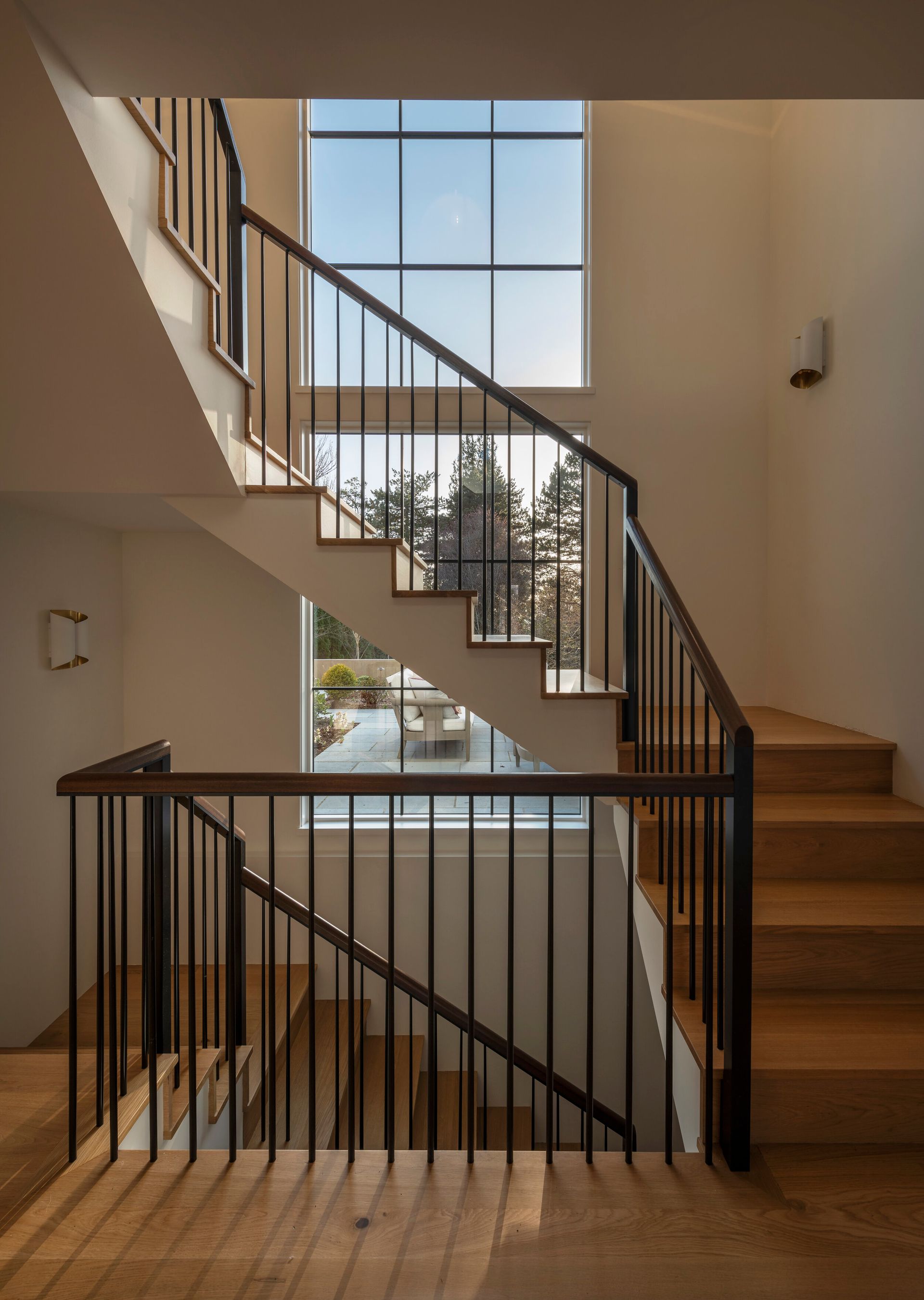 a wooden staircase with a metal railing and a large window