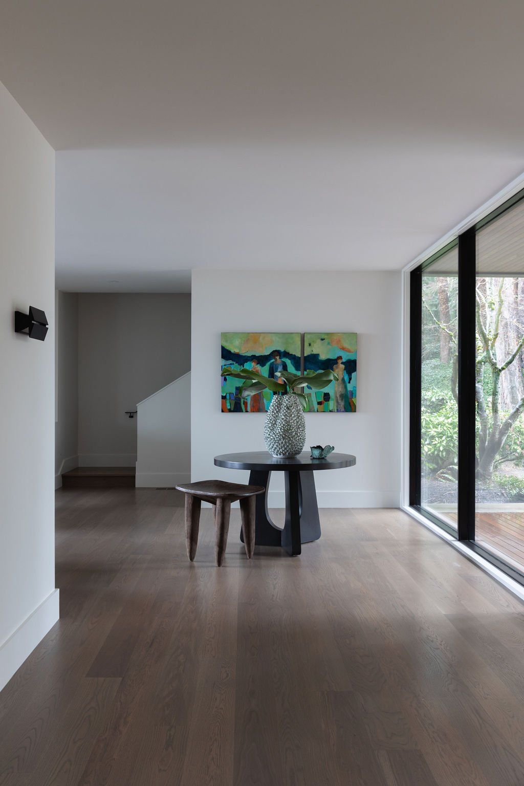 a room with a table and chairs and a painting on the wall