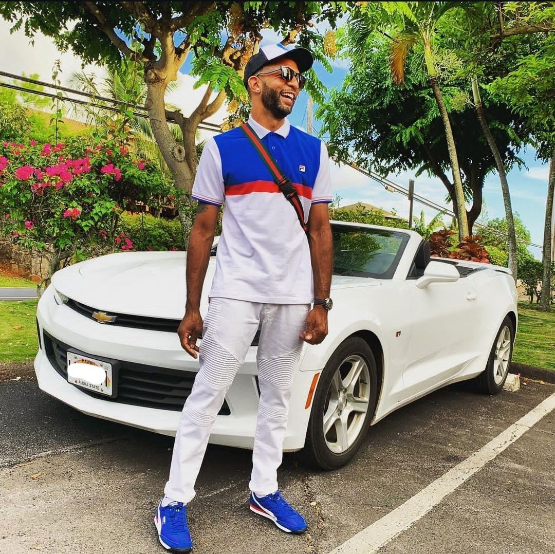 A man is standing in front of a white car