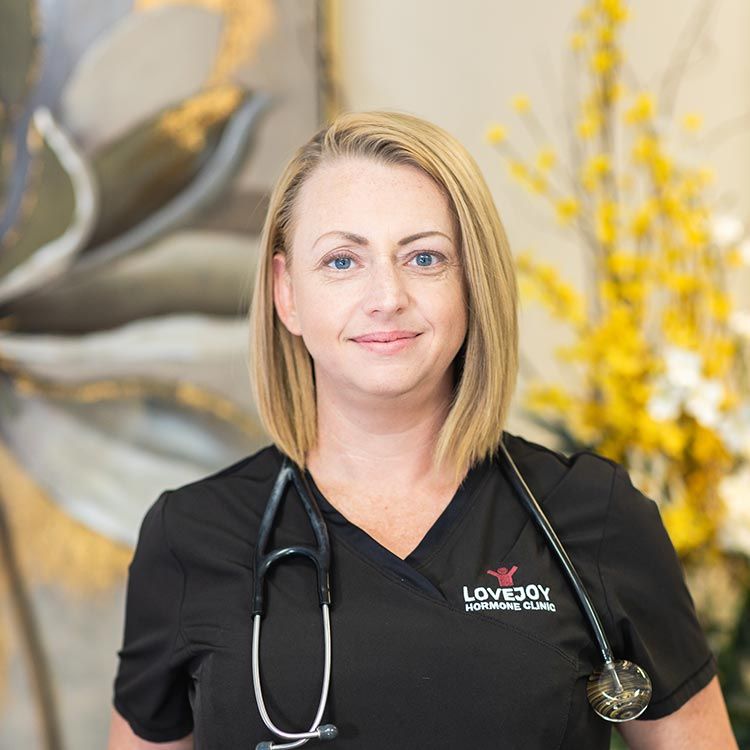 A woman wearing a black scrub top with a stethoscope around her neck