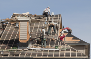 team of roofers repairing roof of a house