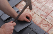 contractor hammering tiles on roof