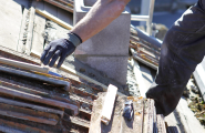 close up man reaching out for damaged roof tiles