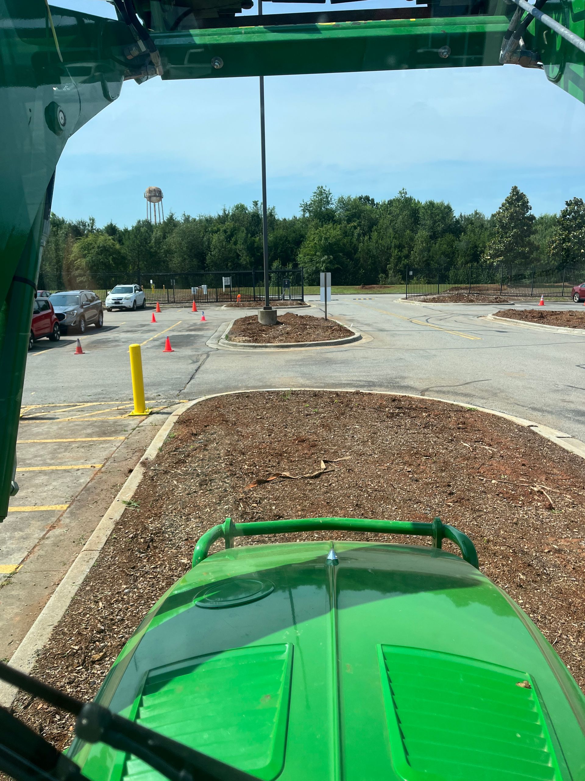 A green tractor is parked in a parking lot