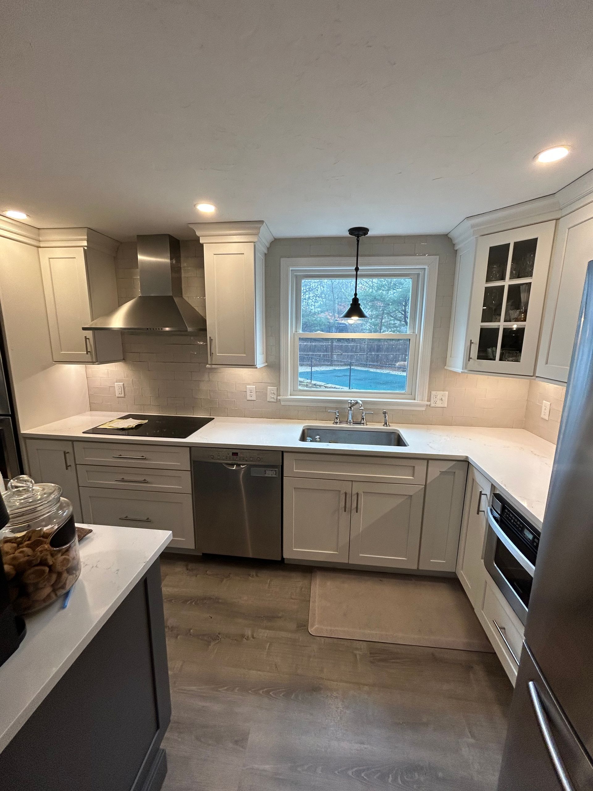 A kitchen with white cabinets and stainless steel appliances