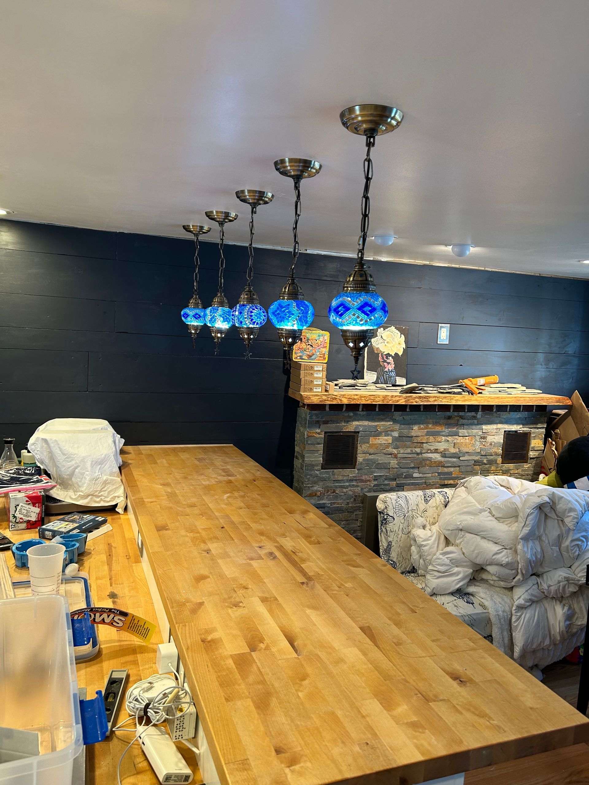 A wooden table with blue lamps hanging from the ceiling in a room.