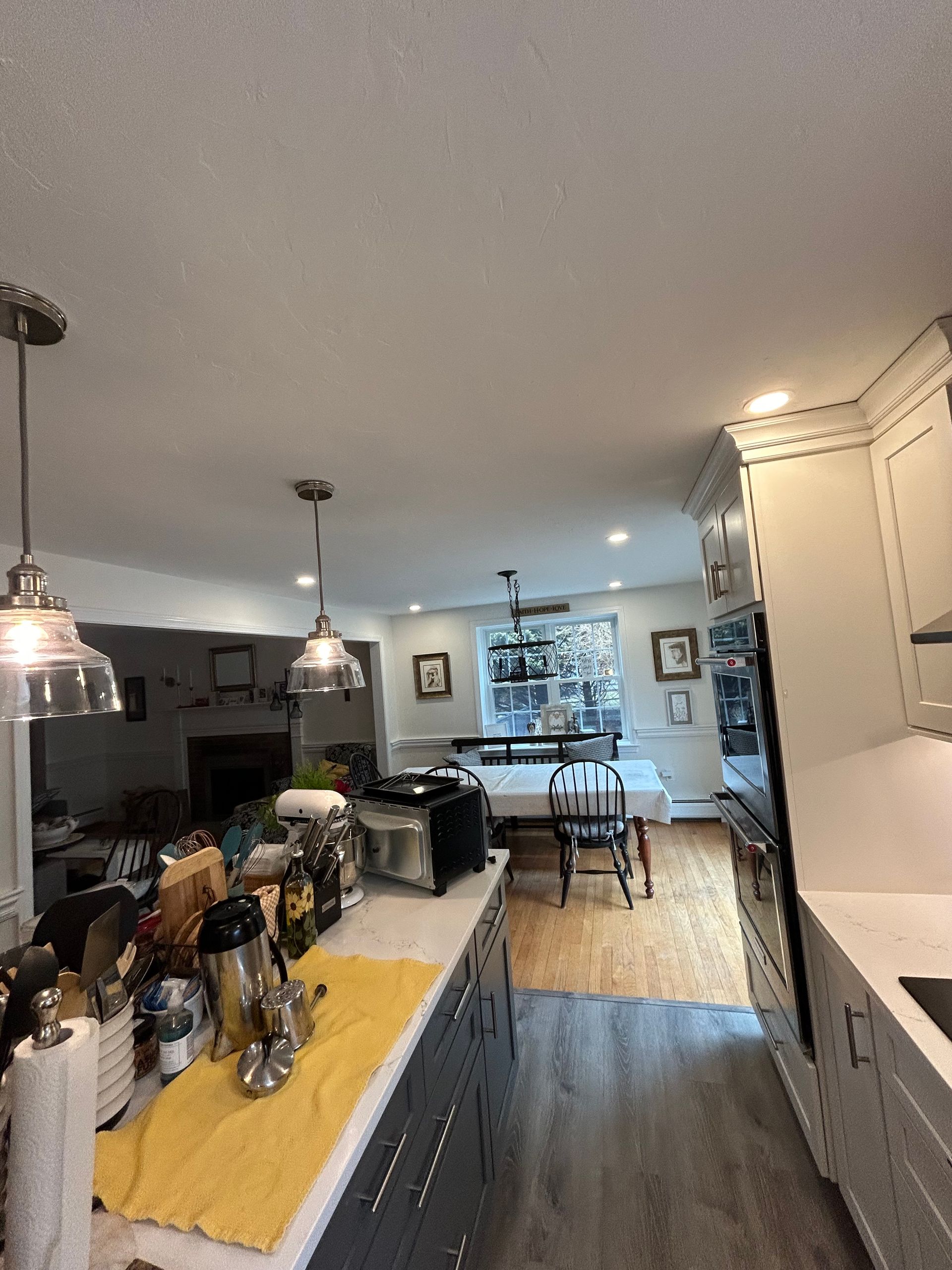A kitchen with white cabinets and a yellow towel on the counter.