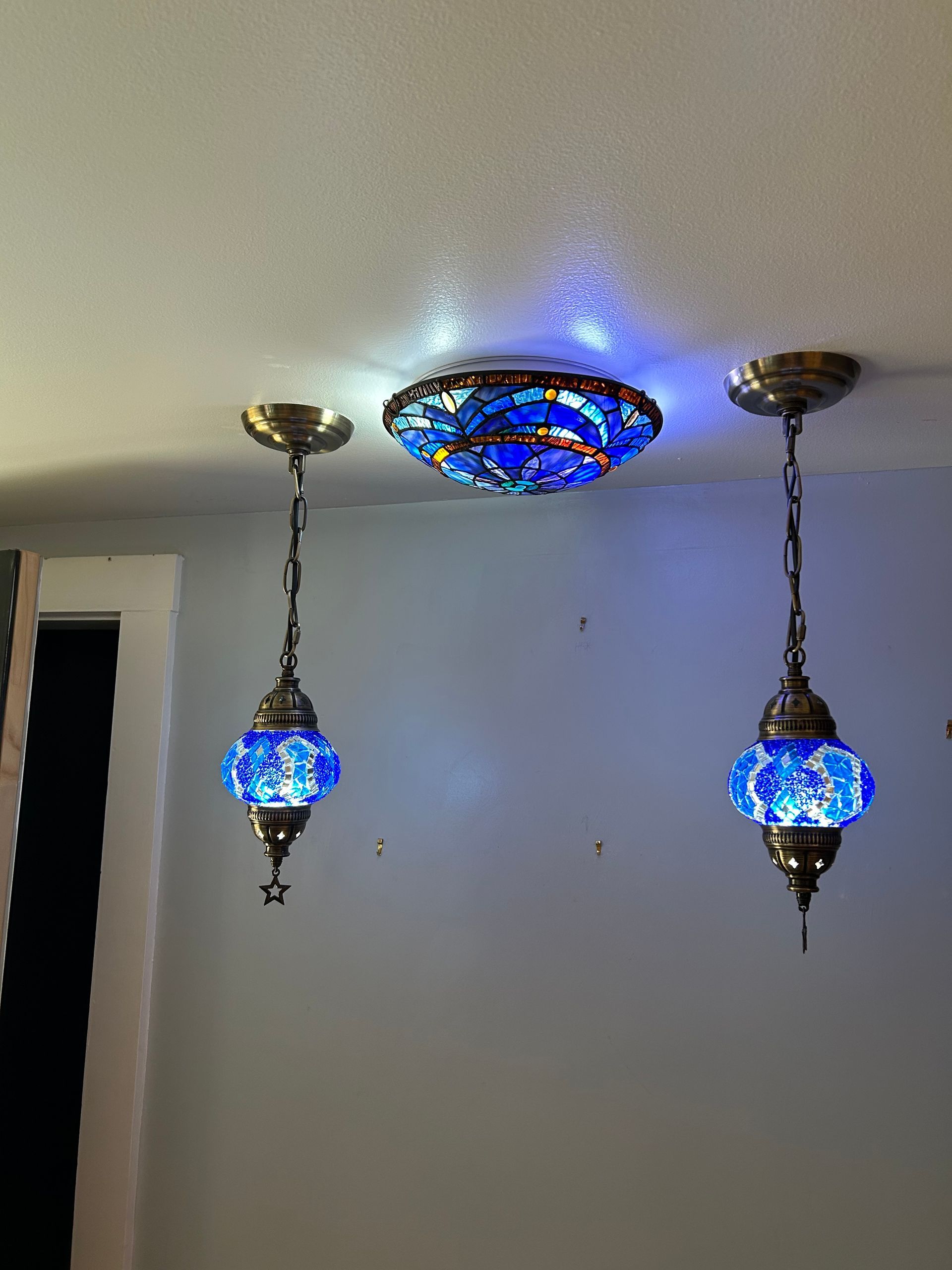 Two blue lamps are hanging from the ceiling in a room.