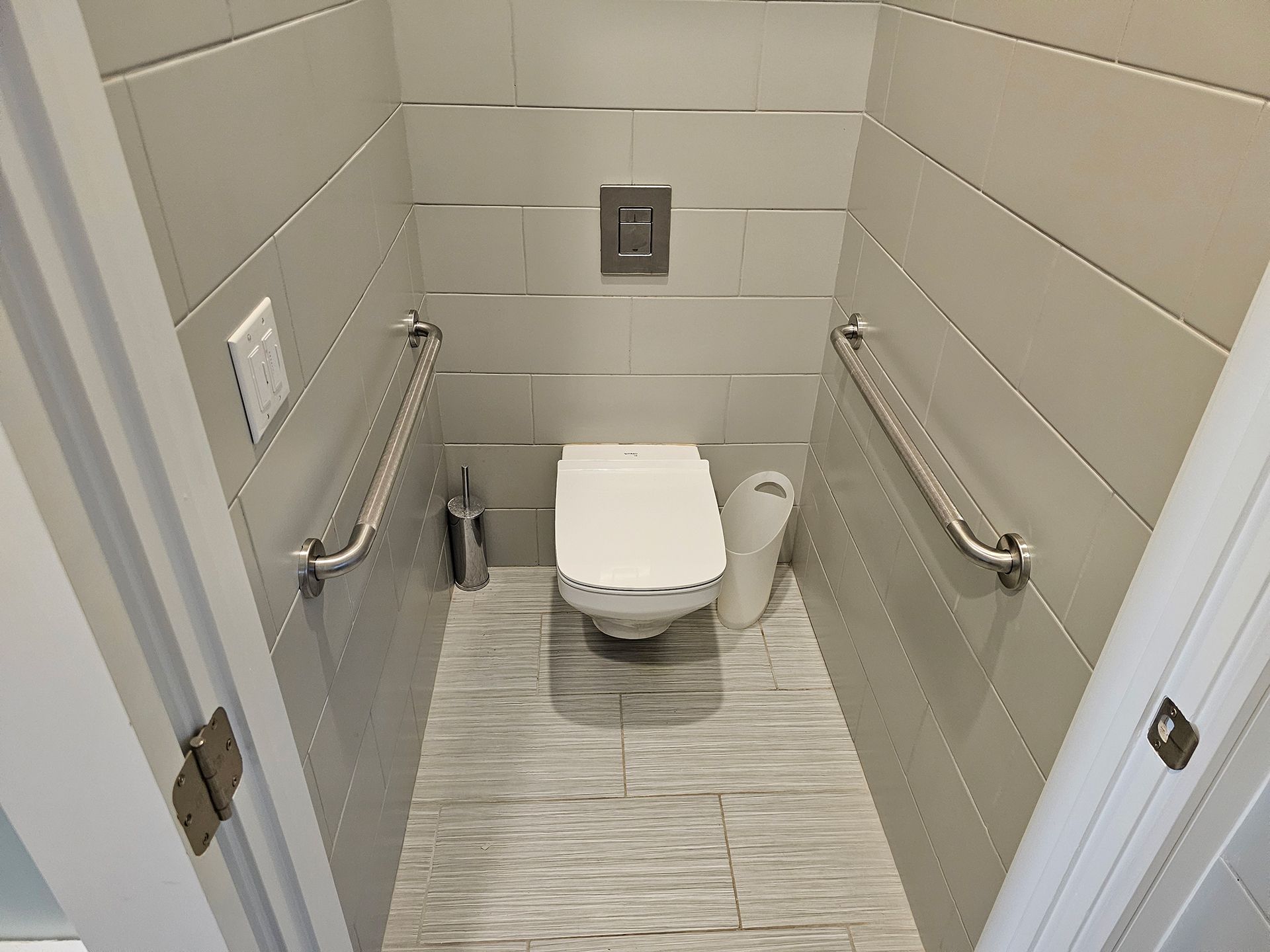 A small bathroom with a toilet and a paper towel dispenser.