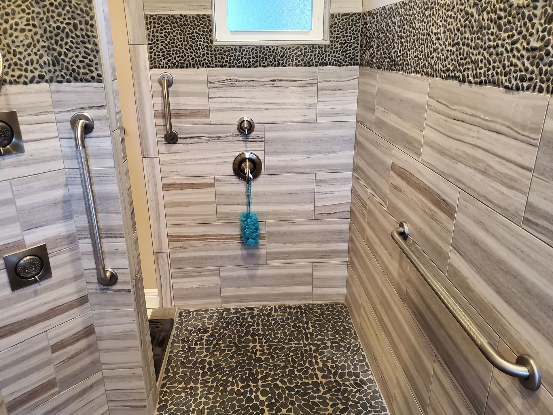 A bathroom with a walk in shower and a window.