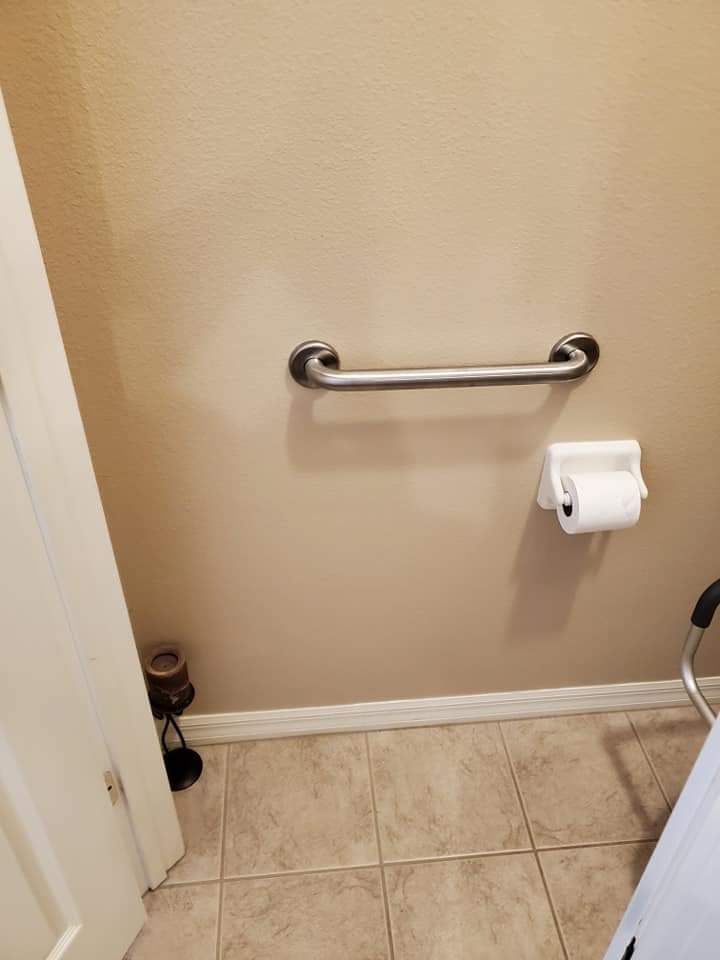 A bathroom with a toilet paper holder and a walker.