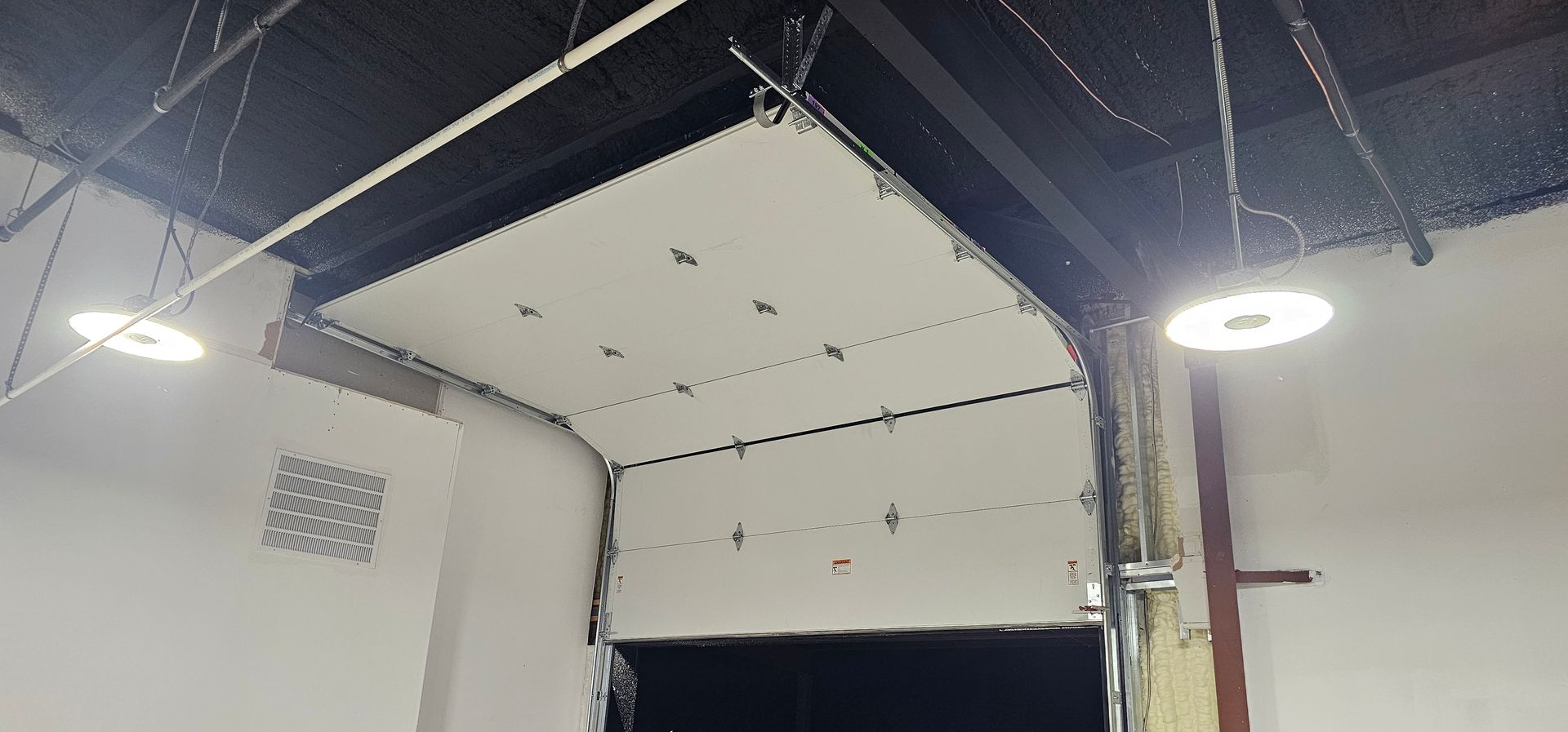 A garage door is open and hanging from the ceiling.