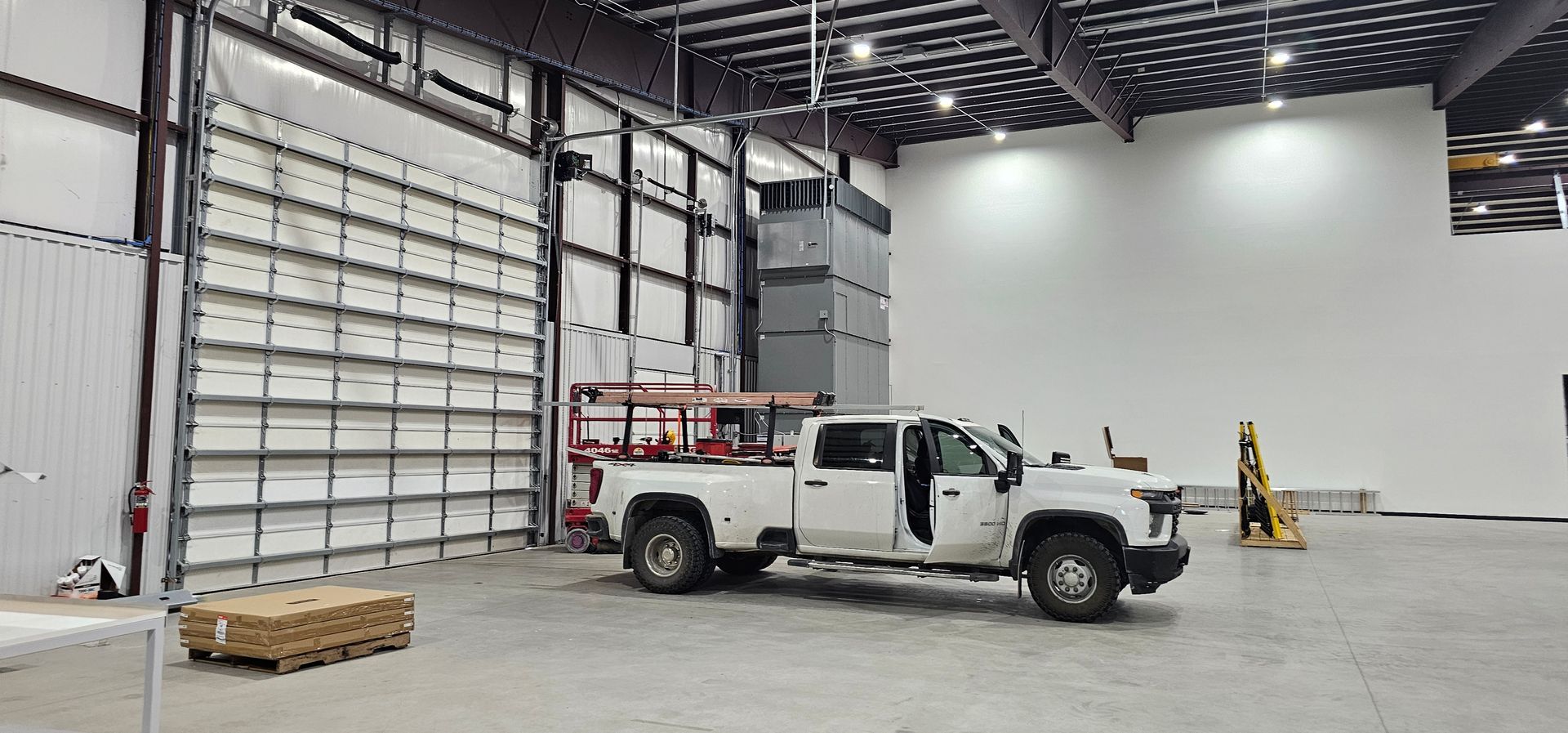 A white truck is parked in a large warehouse.