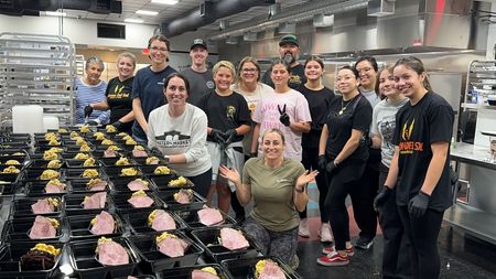 A group of people are posing for a picture in a kitchen.