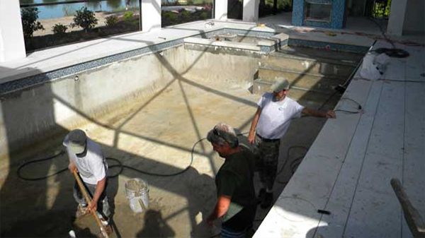 A group of men are working on a swimming pool