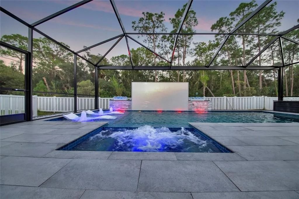 A large swimming pool with a projector screen in the backyard.