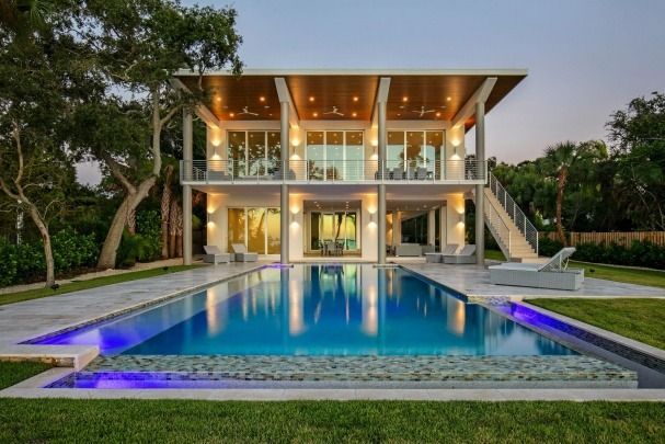A large house with a large swimming pool in front of it.
