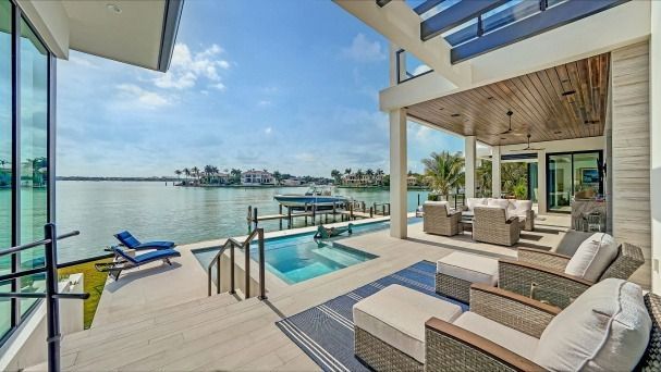 There is a large swimming pool in the backyard of a house.