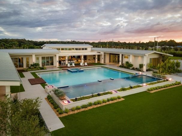 An aerial view of a large house with a large swimming pool in the backyard.