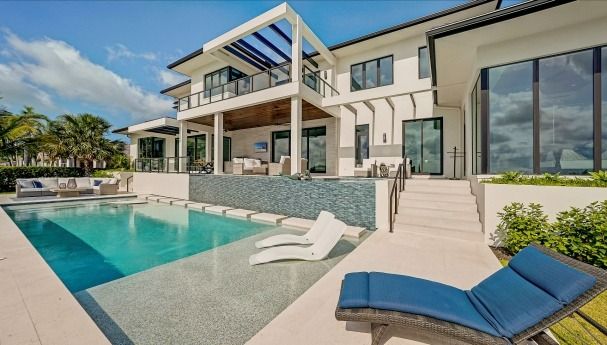 A large house with a swimming pool in front of it
