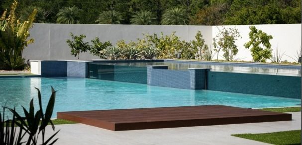 A large swimming pool with a wooden platform in the middle
