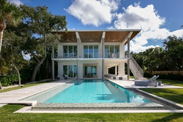 A house with a large swimming pool in front of it