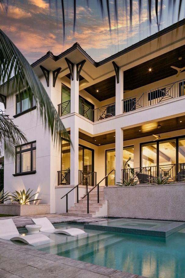 A large white house with a swimming pool in front of it.