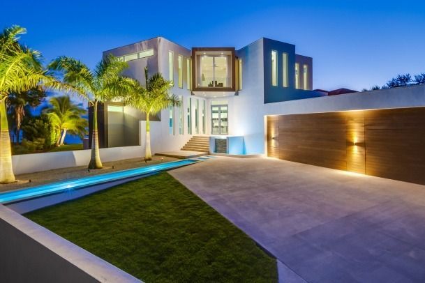 A large house with a swimming pool in front of it