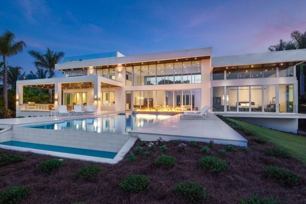 A large house with a swimming pool in front of it