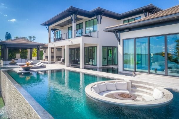 A large house with a swimming pool in front of it.