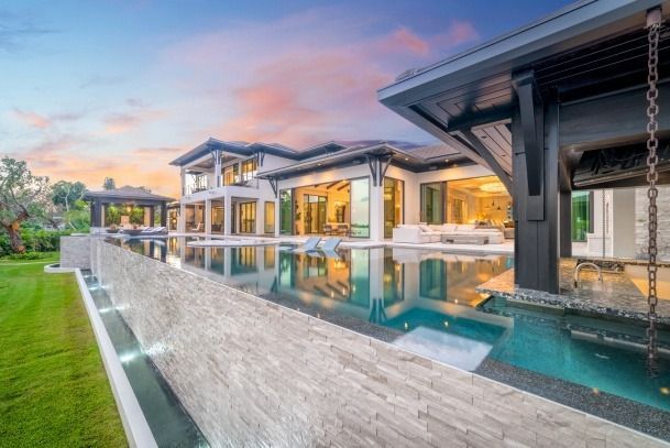 A large house with a swimming pool in front of it.