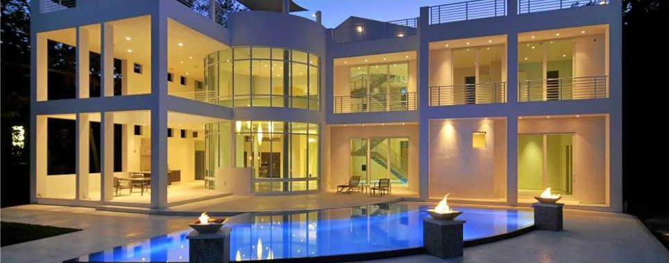 A large house with a swimming pool in front of it