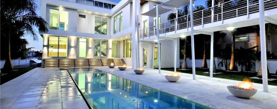 A large white house with a swimming pool in front of it