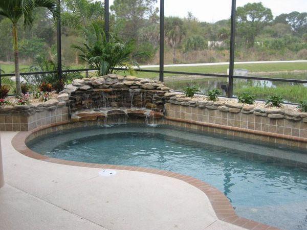 A large swimming pool with a waterfall in the middle