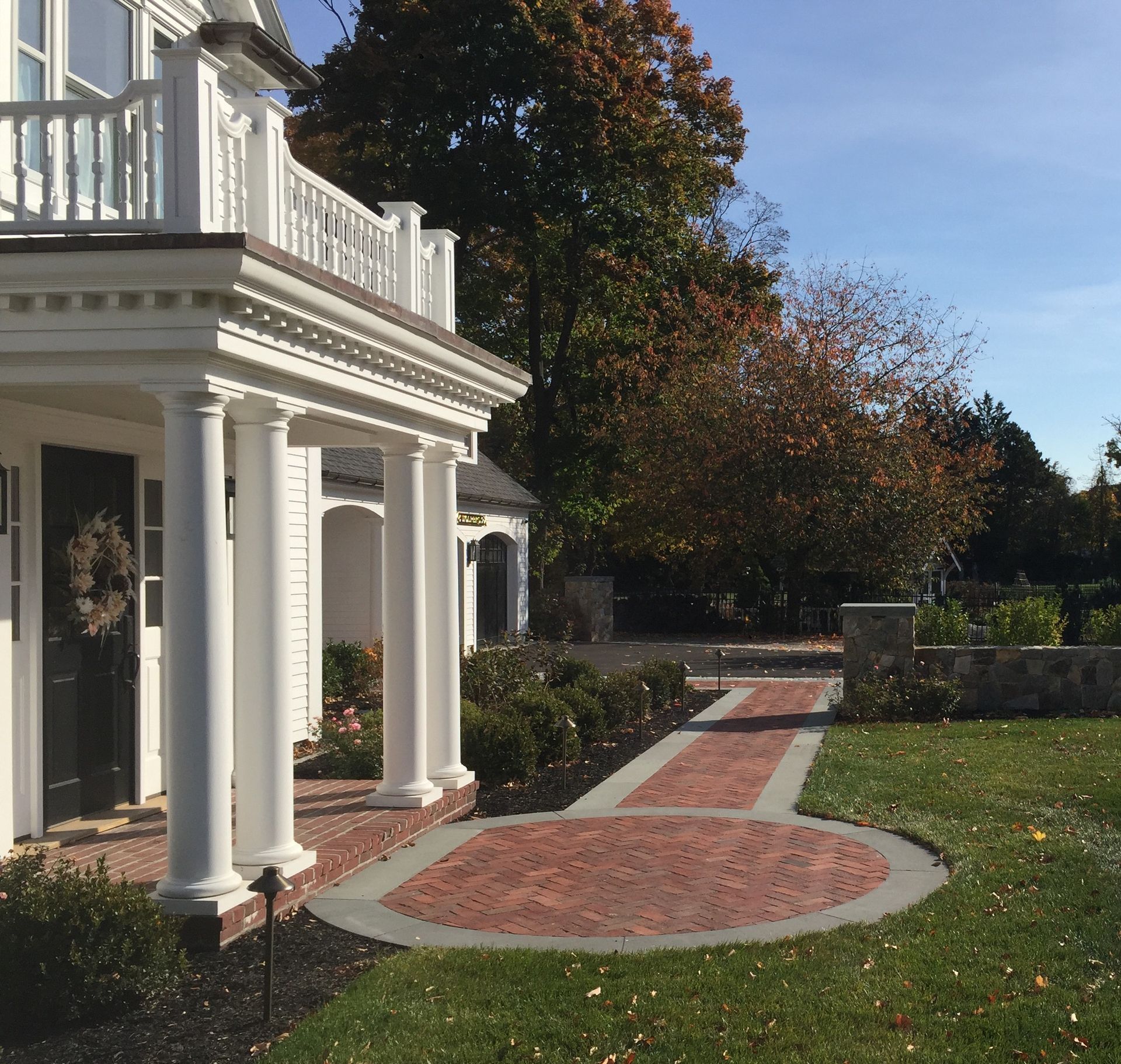 A white house with a brick walkway leading to it.