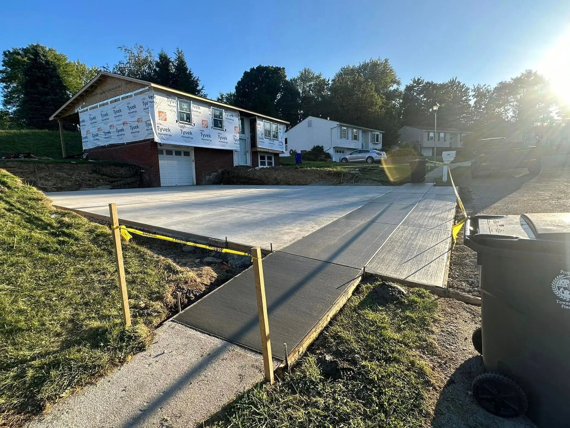Concrete construction with new house under construction; sunshine.
